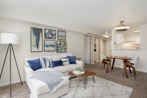 a living room with a white couch and a dining room table